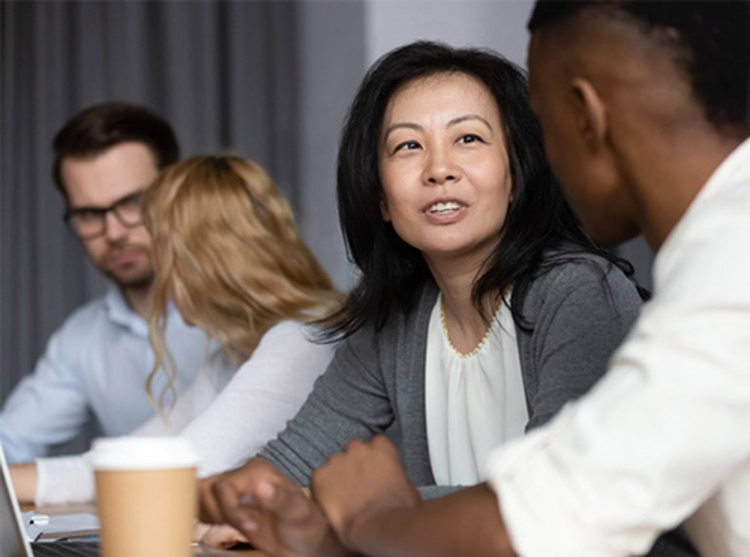 Asian middle-aged woman mentor teach African guy millennial intern